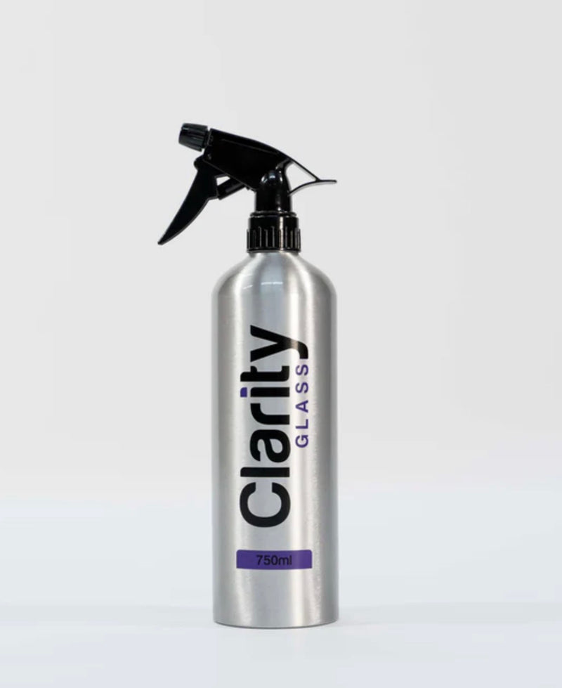 A 750ml silver aluminum spray bottle of Clarity Glass cleaning solution with a black trigger sprayer, set against a plain light gray background.