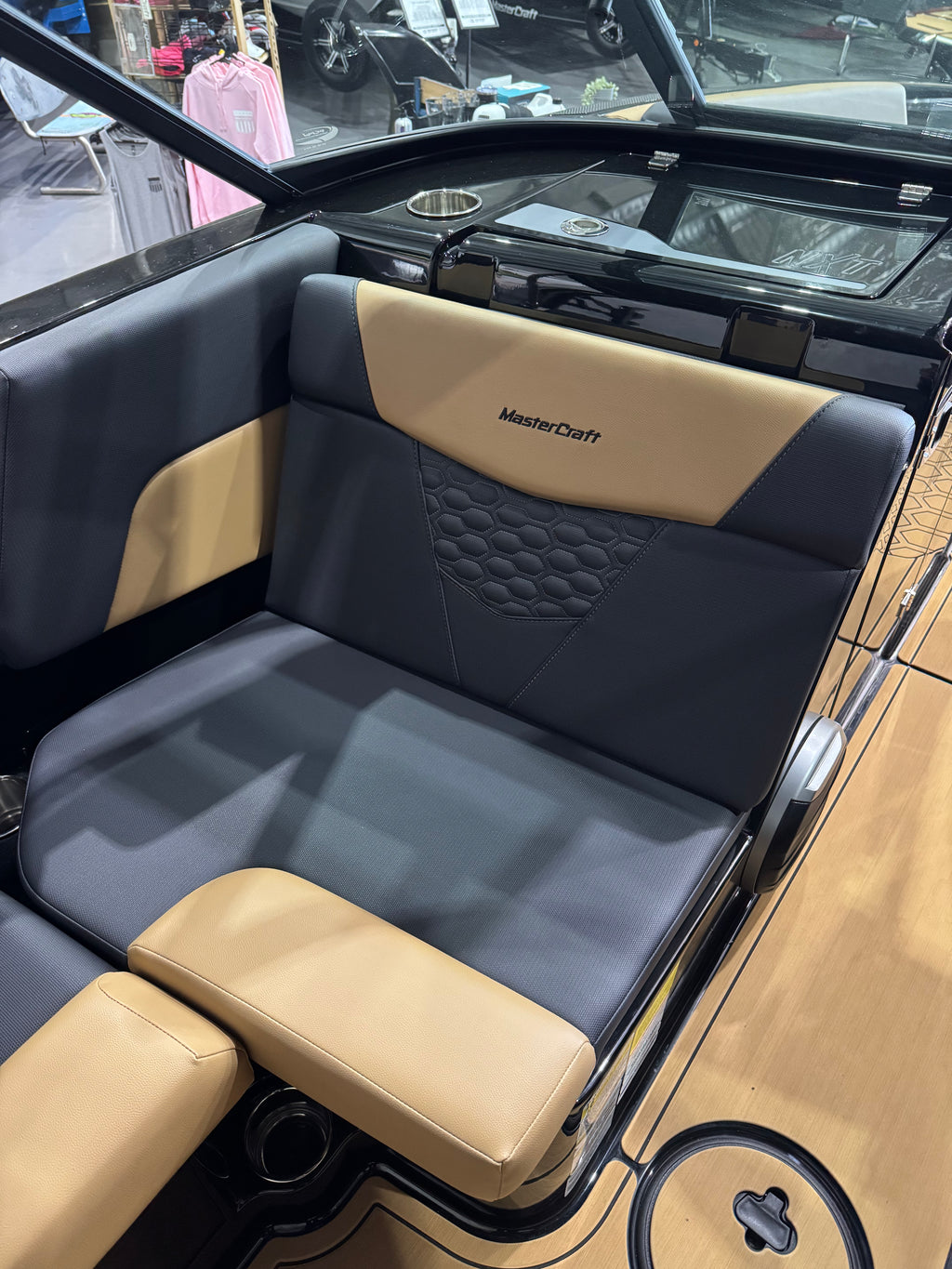 MasterCraft boat seat upholstered in dark gray and tan vinyl, featuring a quilted diamond pattern on the backrest and the MasterCraft logo.
